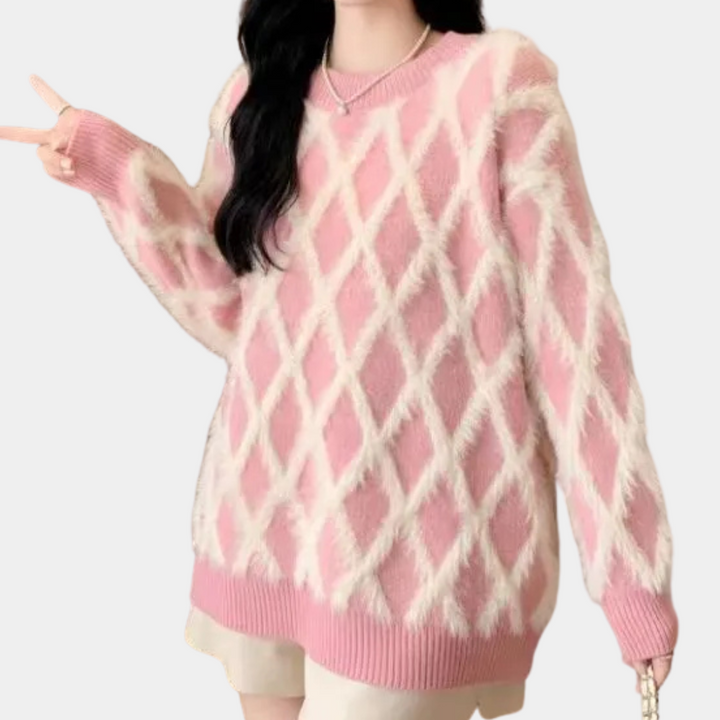 Roze gebreide trui met ruitpatroon, lange mouwen en ronde hals, gedragen door model. Modieuze dameskleding, herfst-winter stijl.